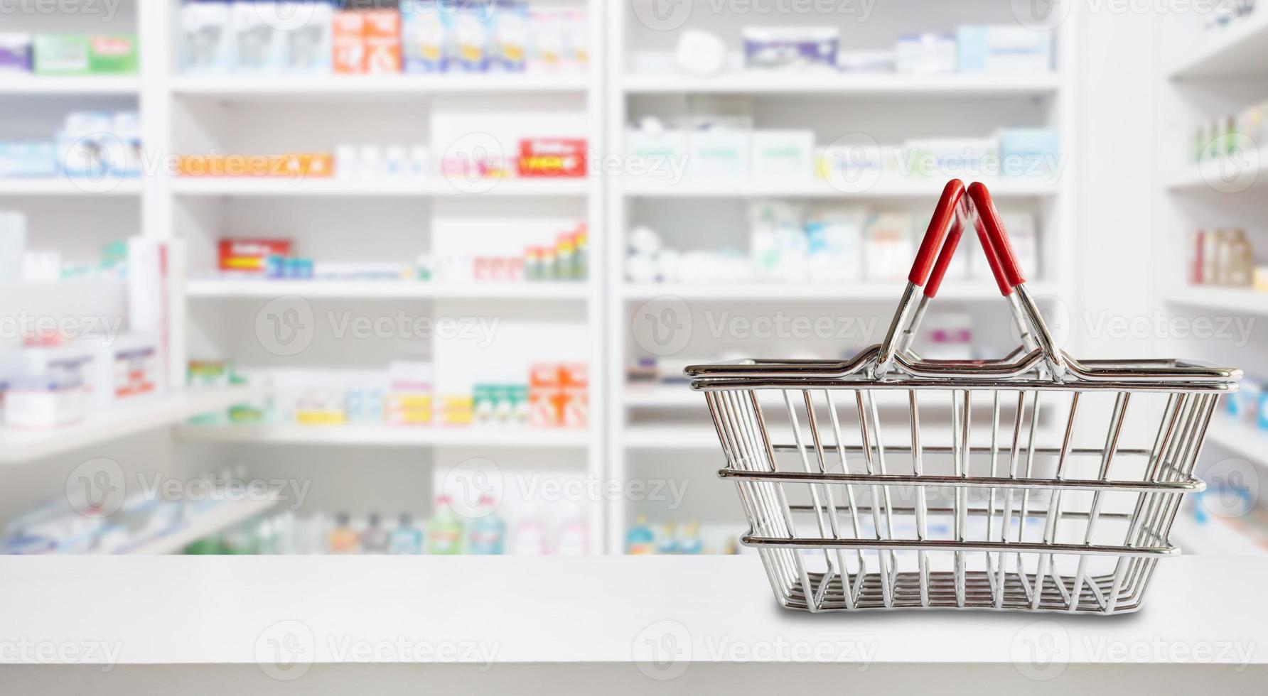 panier vide sur le comptoir de la pharmacie de la pharmacie avec des étagères floues de médicaments et de suppléments de vitamines photo
