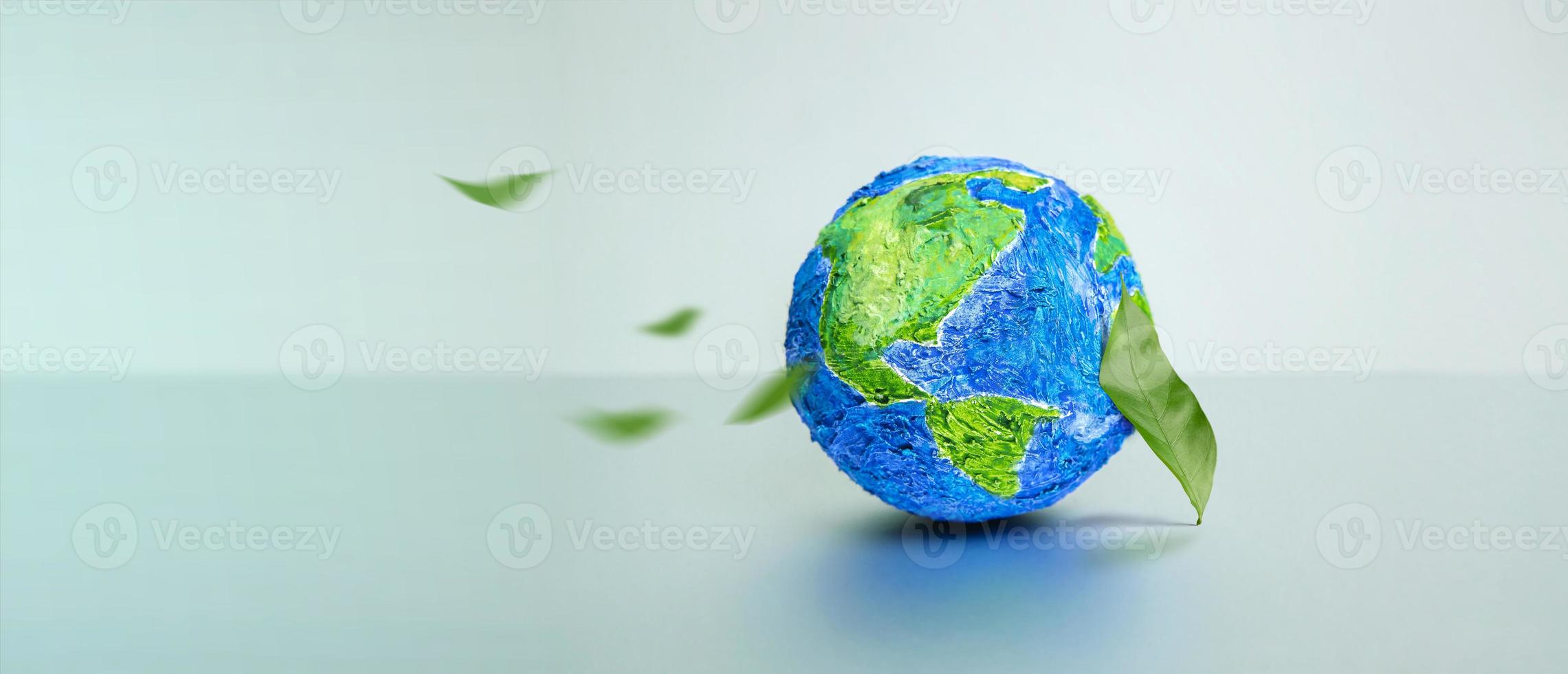 concept de la journée mondiale de la terre. énergie verte, ressources renouvelables et durables. protection de l'environnement et de l'écologie. feuille verte par le globe photo