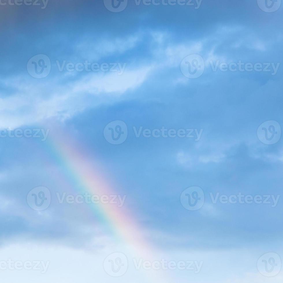 arc-en-ciel dans les nuages de pluie dans le ciel bleu du soir photo