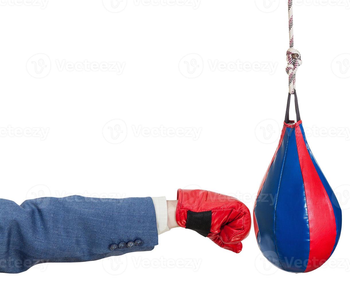 homme en costume avec un gant de boxe frappe un sac de boxe photo