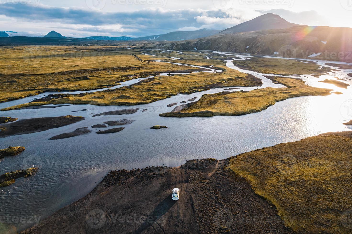 véhicule à quatre roues motrices garé près de la grande traversée de la rivière le soir sur les régions rurales éloignées des hautes terres islandaises photo