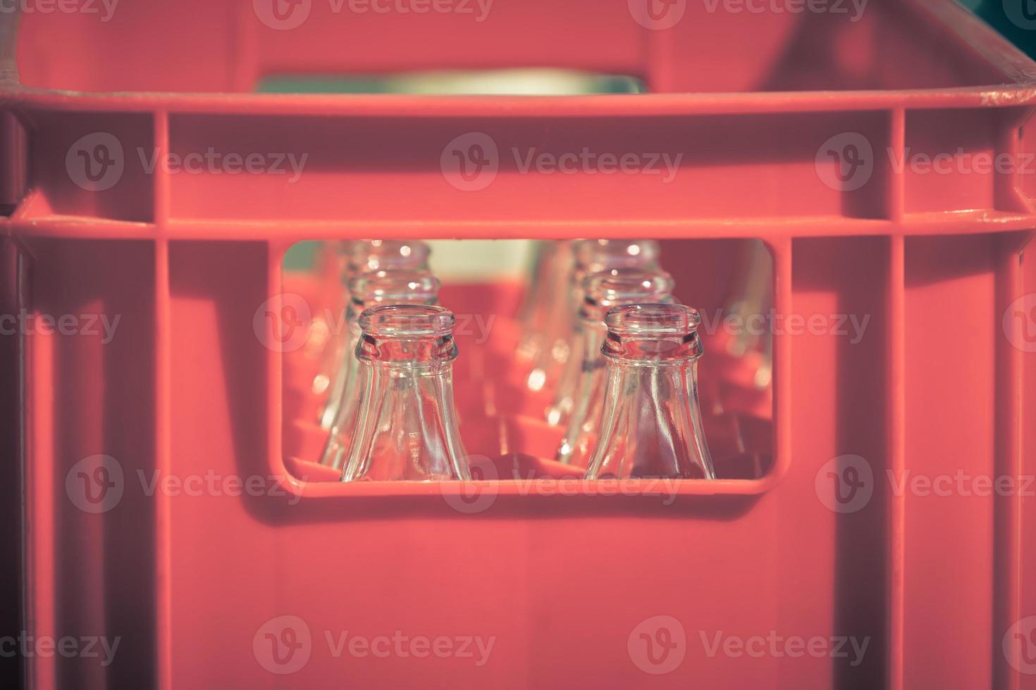 caisse en plastique rouge avec des bouteilles en verre vides photo