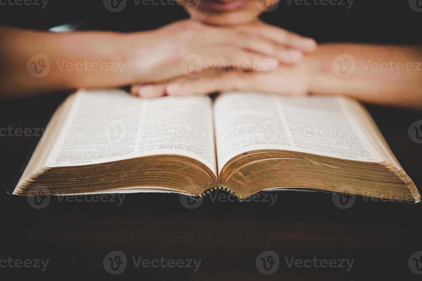 main de jeune femme tenant la sainte bible avec étude à la maison. livre de lecture chrétienne femelle adulte à l'église. fille apprenant la spiritualité religieuse avec prier Dieu. concept de foi en éducation des étudiants. photo