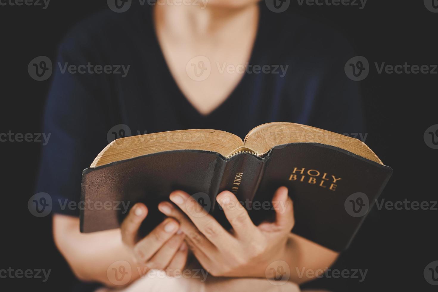 main de jeune femme tenant la sainte bible avec étude à la maison. livre de lecture chrétienne femelle adulte à l'église. fille apprenant la spiritualité religieuse avec prier Dieu. concept de foi en éducation des étudiants. photo