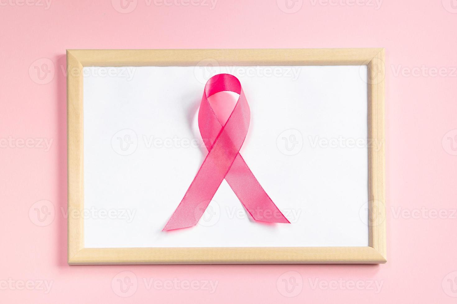 ruban rose sur fond coloré. symbole du mois de sensibilisation au cancer du sein. concept de soins de santé des femmes. promotion de la campagne de lutte contre le cancer. photo