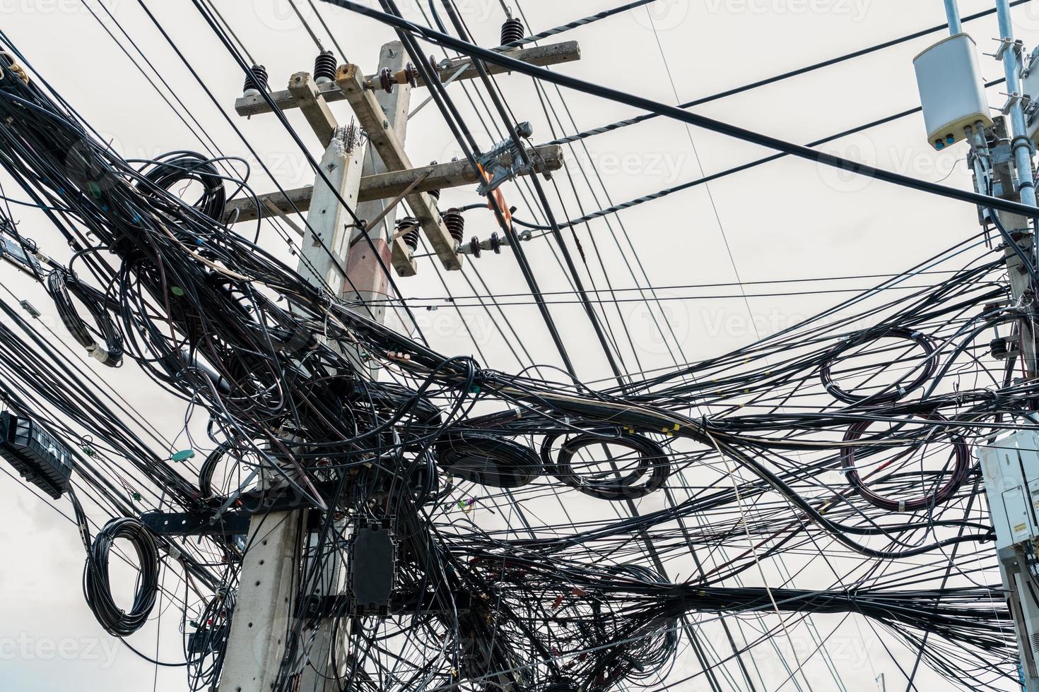 fils électriques emmêlés sur un poteau électrique urbain. désorganisé et désordonné au concept de gestion de l'organisation. gros fils électriques emmêlés. devrait prendre un fil souterrain pour un beau paysage. photo