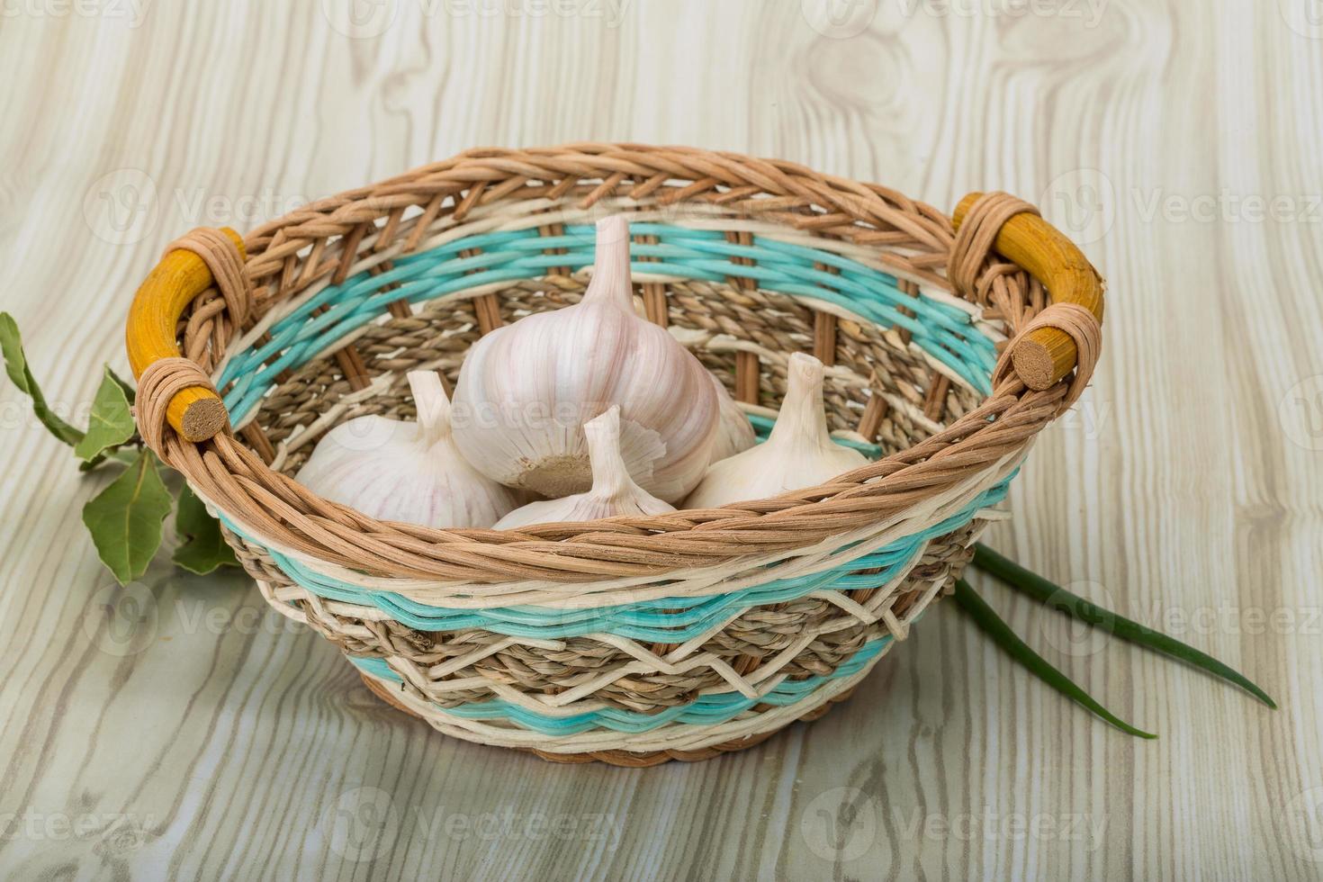 ail dans un panier sur fond de bois photo