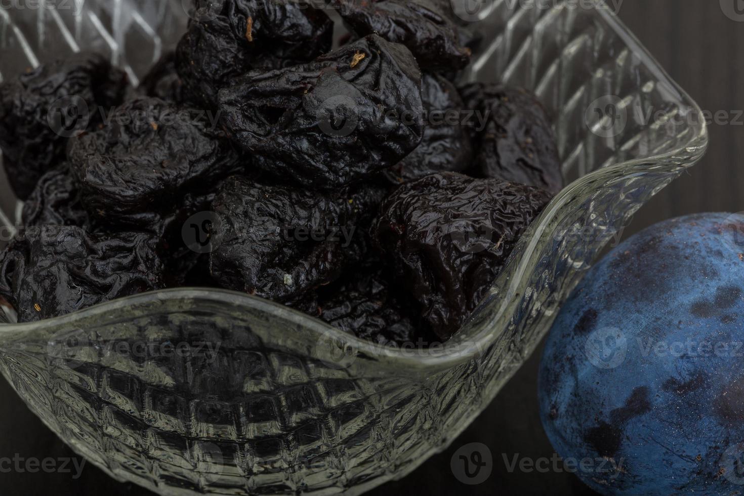 prunes séchées dans un bol sur fond de bois photo