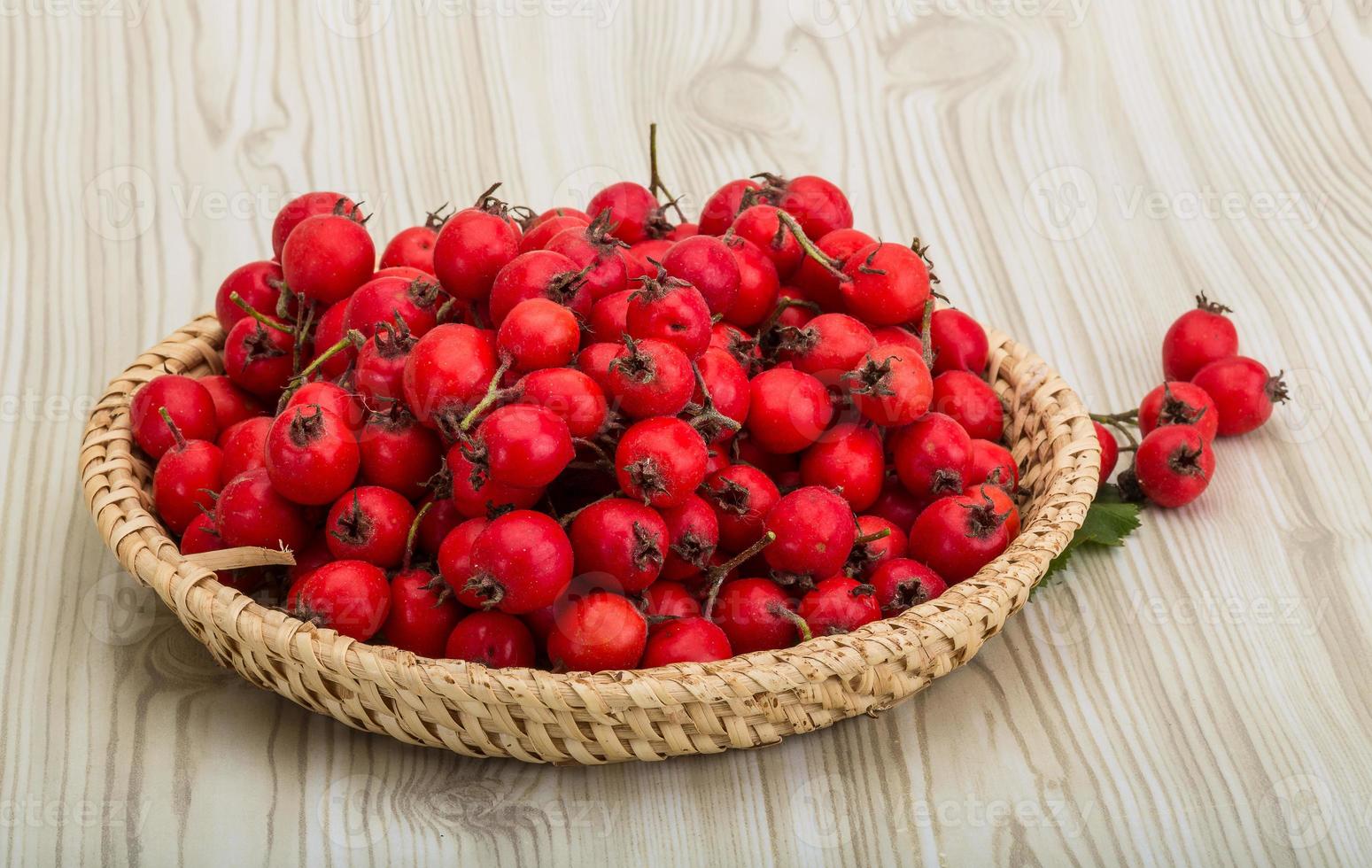 Aubépine dans un panier sur fond de bois photo