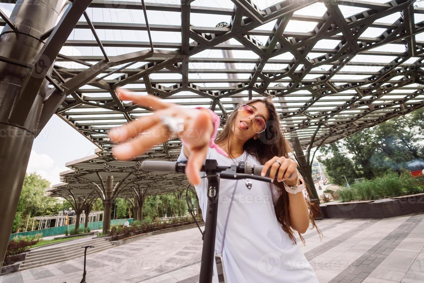 jeune belle femme taquinant et montrant la langue à la caméra dans le parc photo