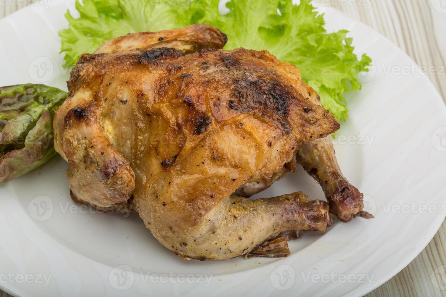 poulet rôti sur la plaque et fond en bois photo