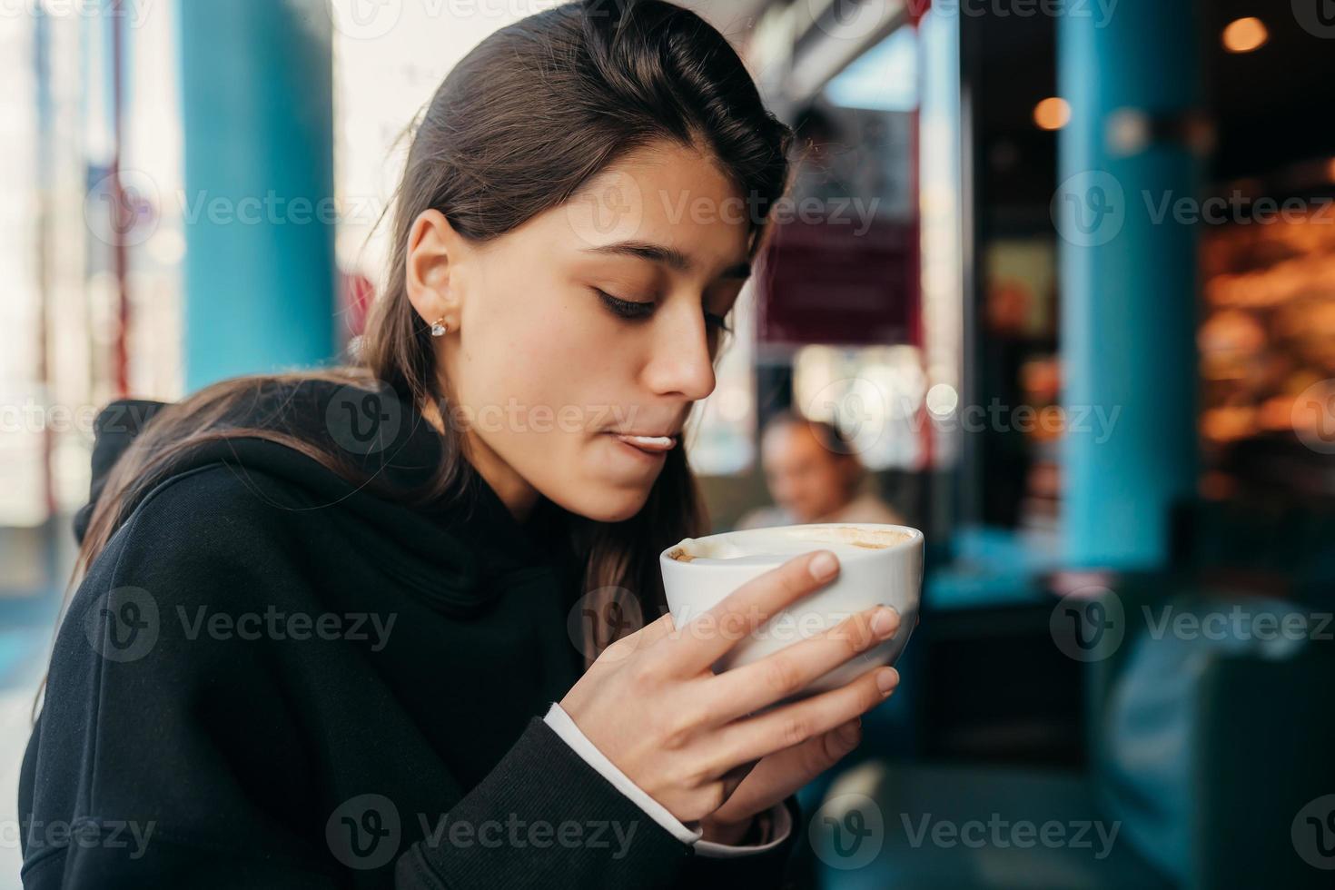 portrait en gros plan d'une jolie femme buvant du café. photo