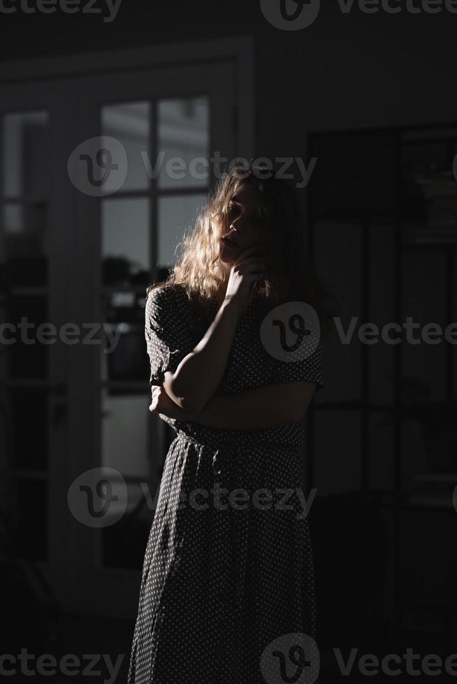 sérieuse belle jeune femme en robe posant pour la caméra. photo