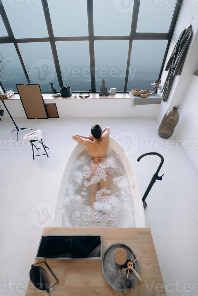 femme détendue prenant un bain, profitant et se relaxant allongée dans la baignoire, vue de dessus photo