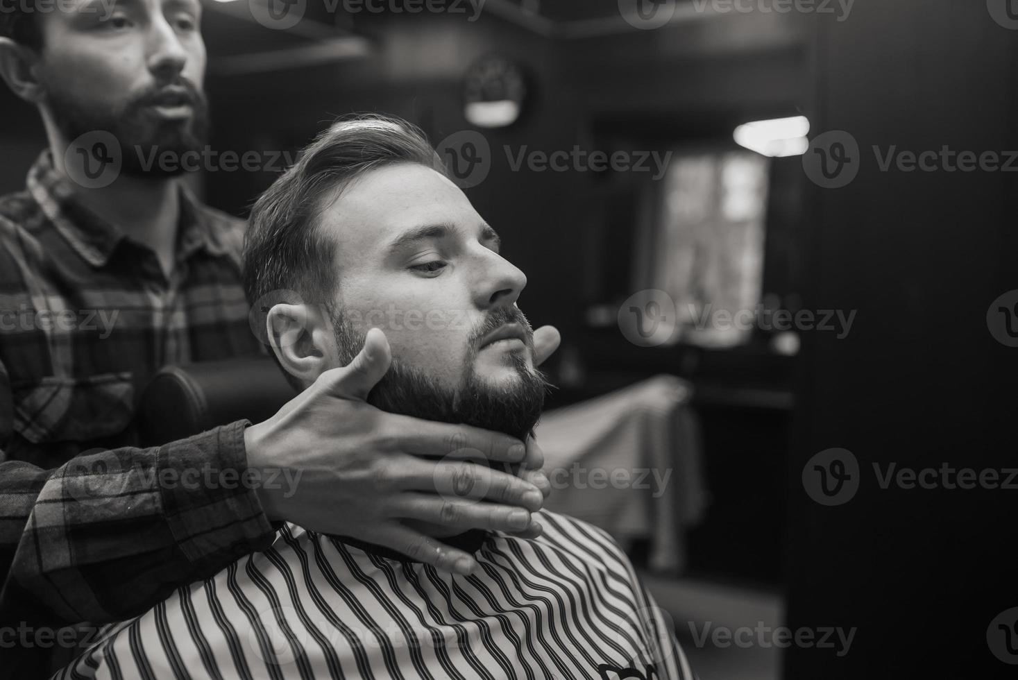 soin du visage appliquant une lotion après rasage dans un salon de coiffure. photo