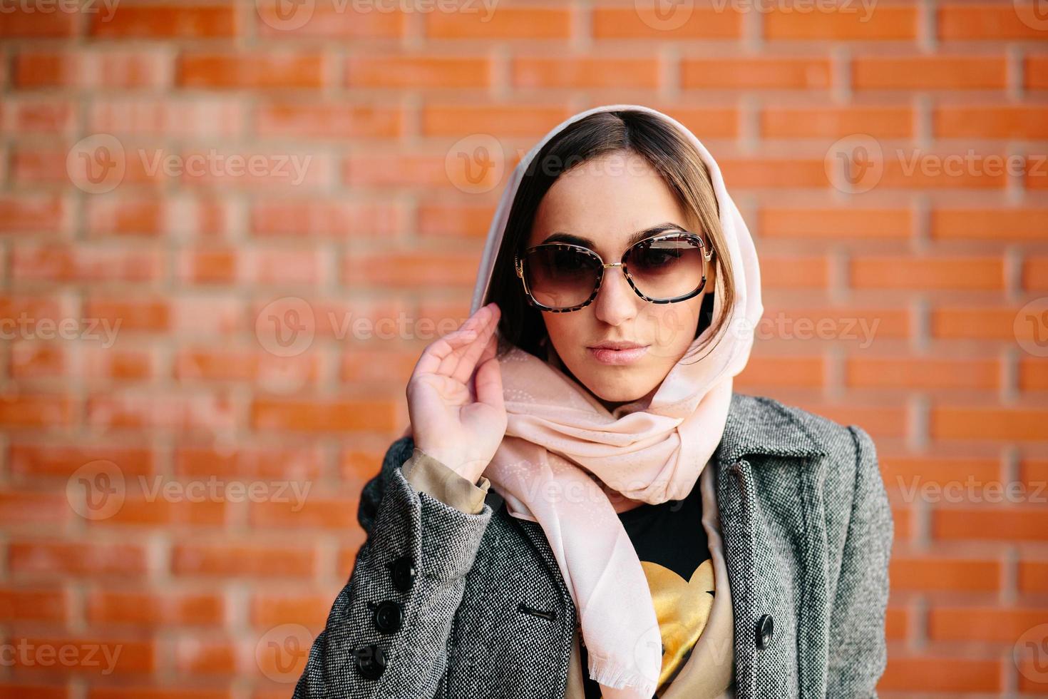 fille posant sur un fond de mur de briques rouges photo