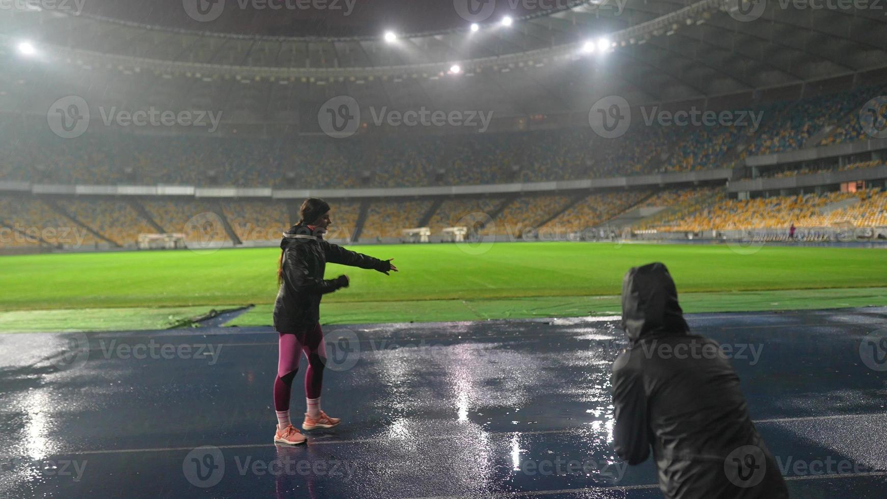 les gens vont faire du sport au stade de nuit par temps de pluie photo