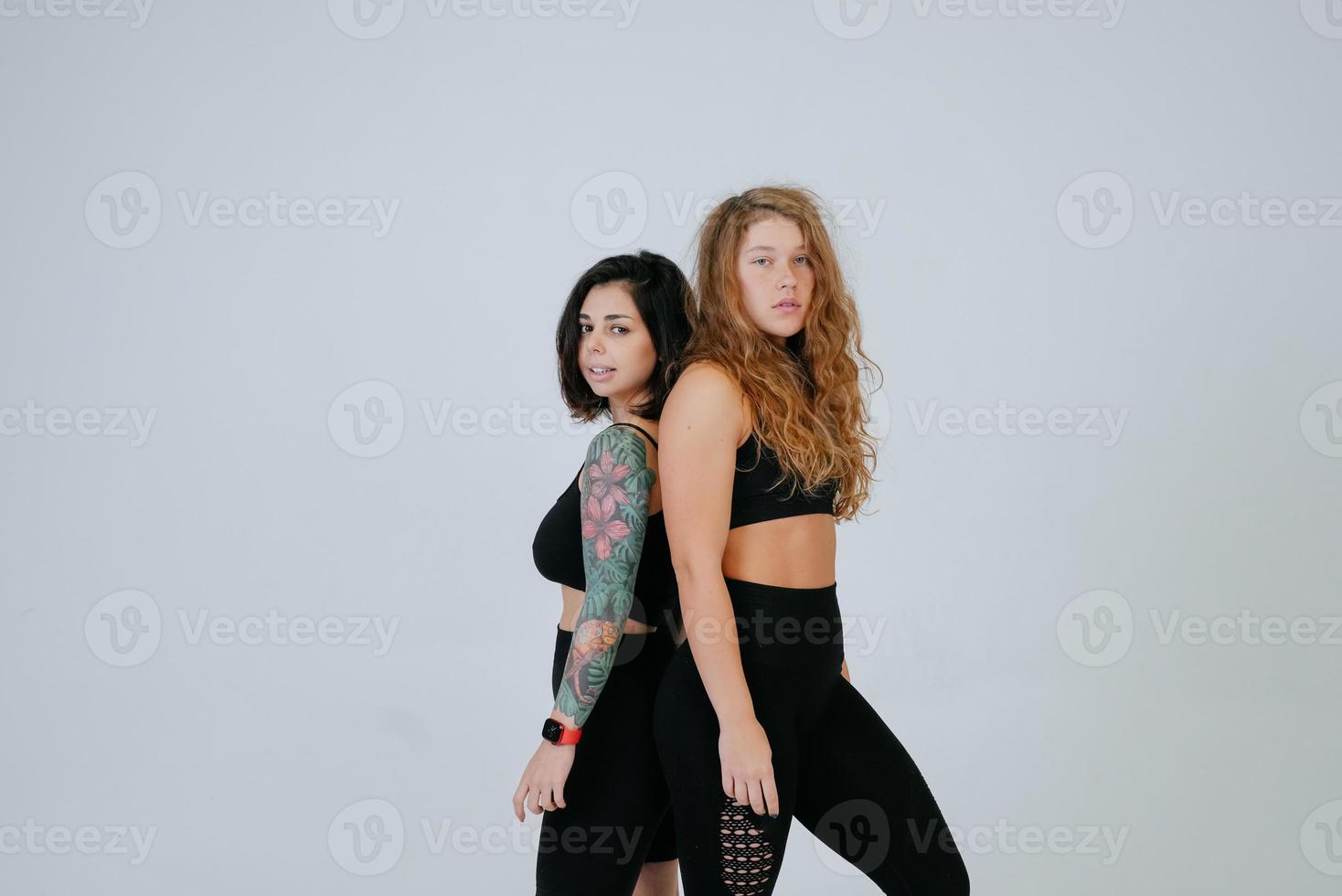 deux jeunes femmes posant sur fond blanc. photo