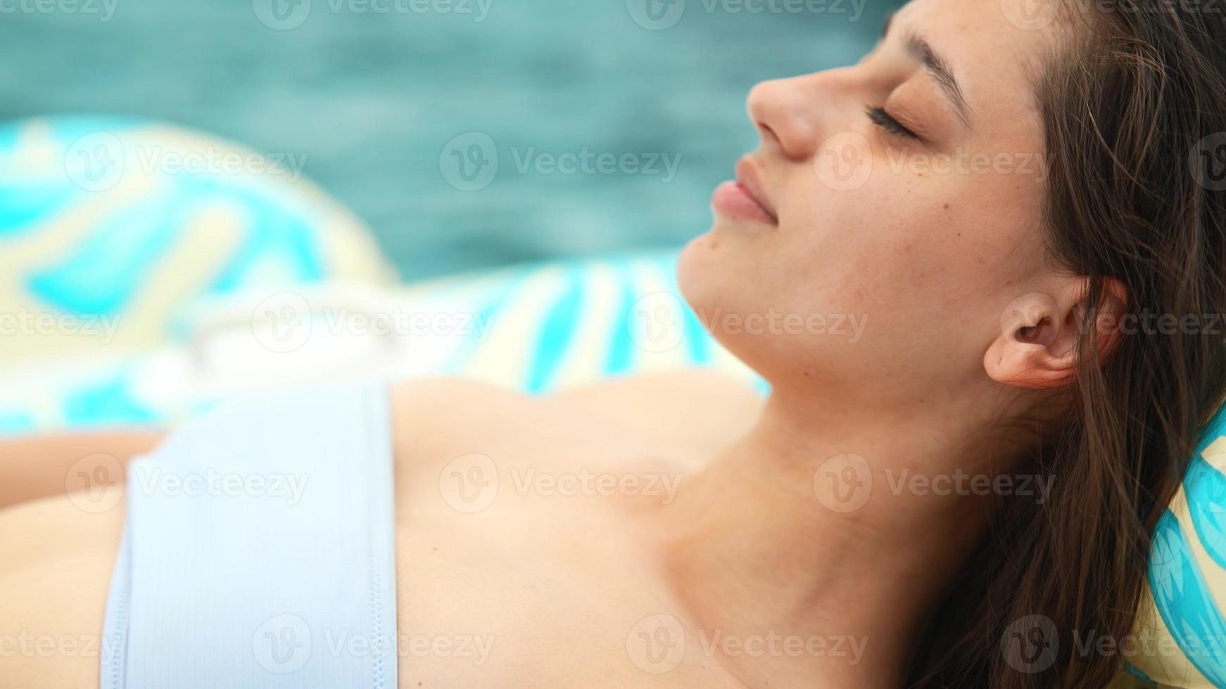 femme sur flamant gonflable flottant dans la piscine. vue rapprochée photo