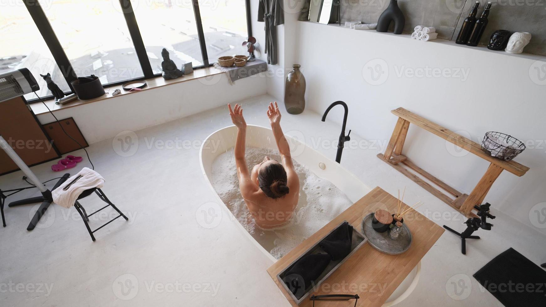 jolie jeune femme prenant un bain à la maison vue arrière photo