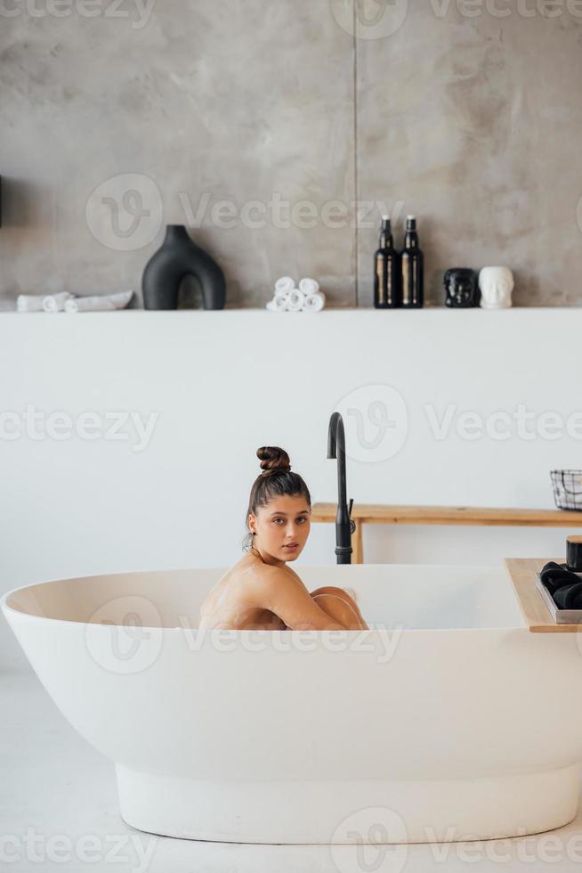 vue latérale d'une femme prenant un bain moussant à la maison photo