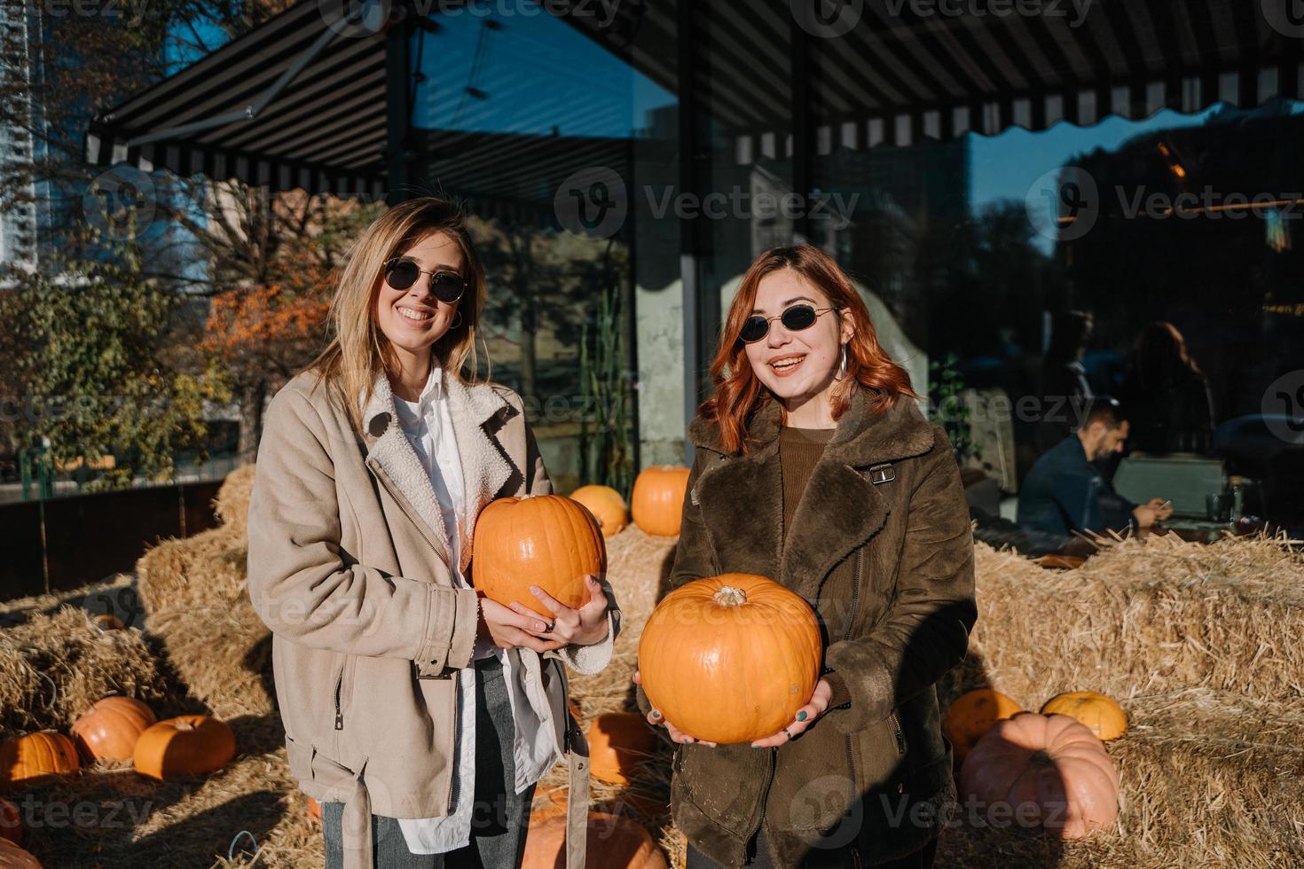 les filles tiennent des citrouilles dans les mains. photos en extérieur.