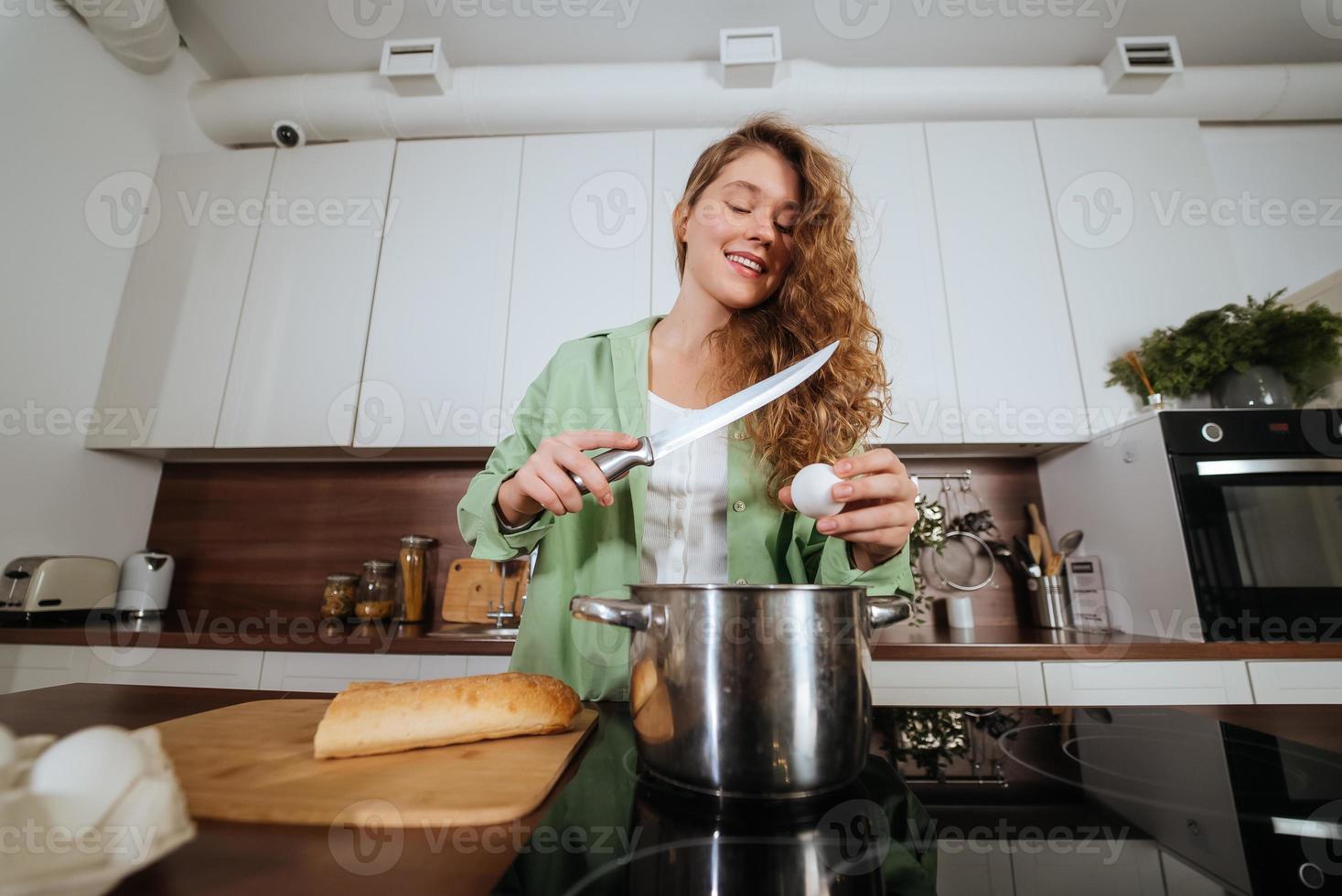 jeune femme prépare la nourriture dans la cuisine. battre des œufs. photo