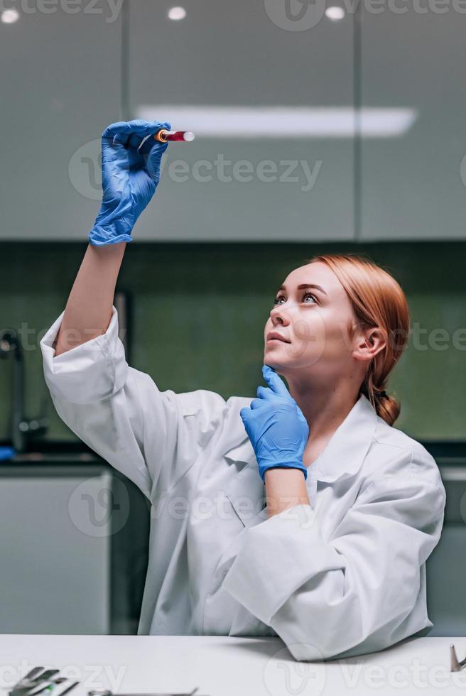 chercheuse médicale ou scientifique regardant un tube à essai dans un laboratoire. photo