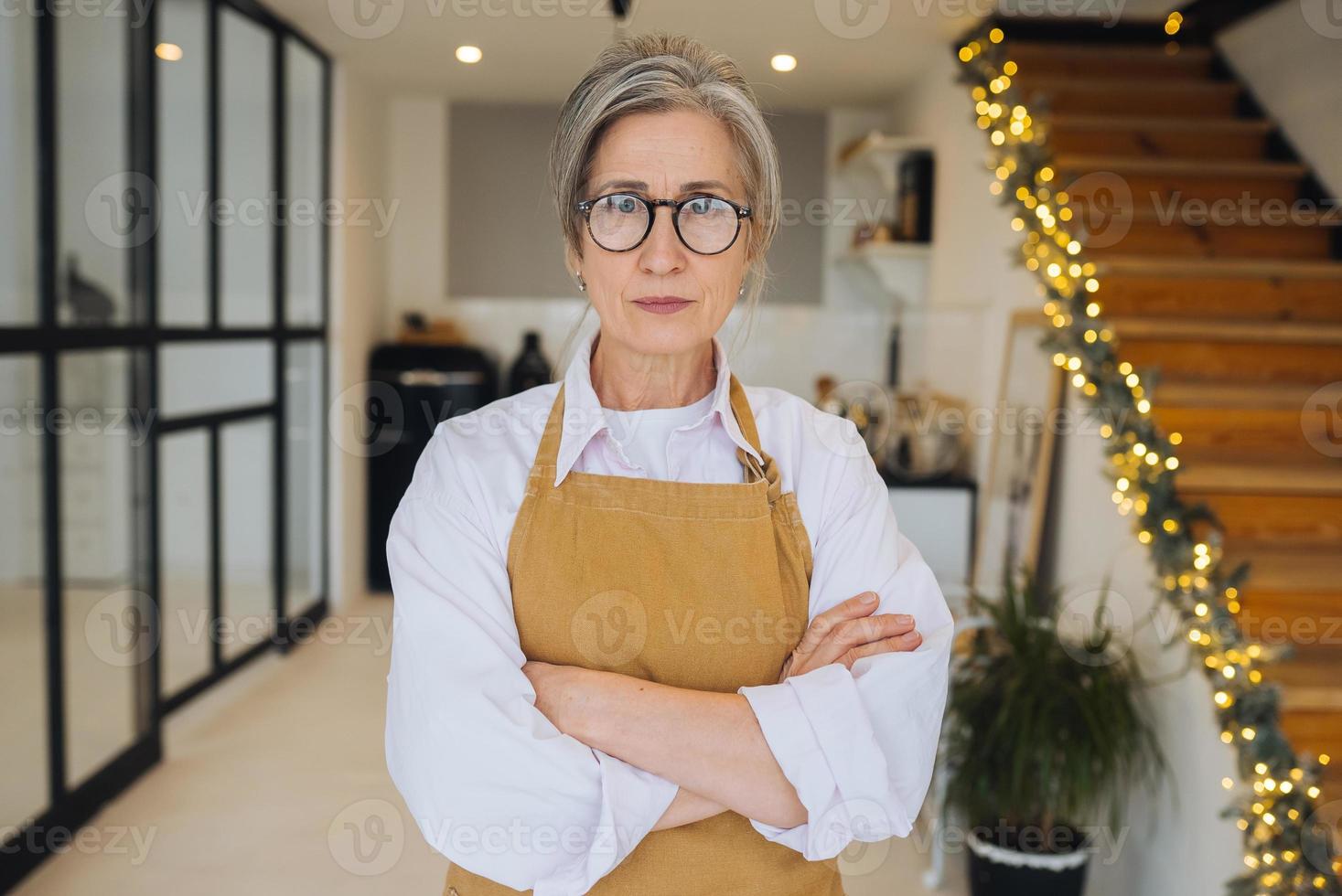 portrait d'une grand-mère stricte debout dans une pose mécontente regardant fixement la caméra en colère photo