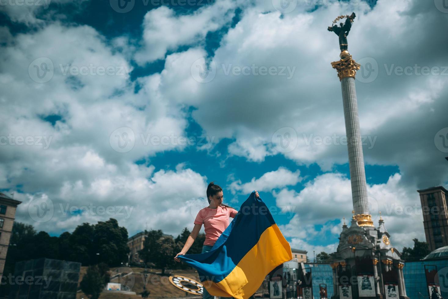 jeune femme avec le drapeau national de l'ukraine dans la rue photo