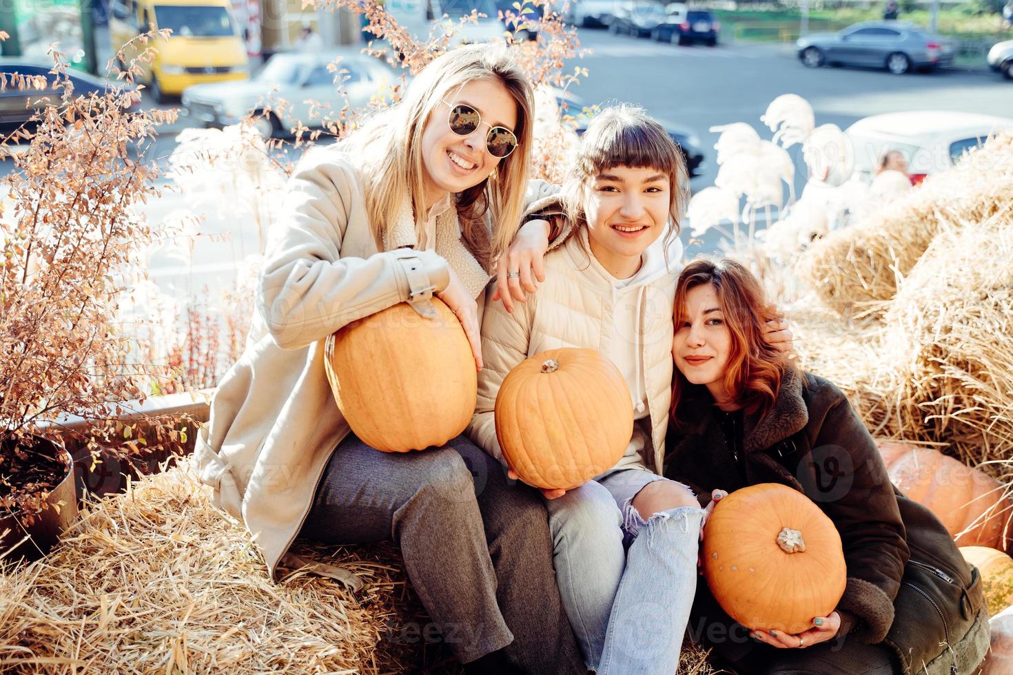 les filles tiennent des citrouilles dans les mains sur le fond de la rue. photo