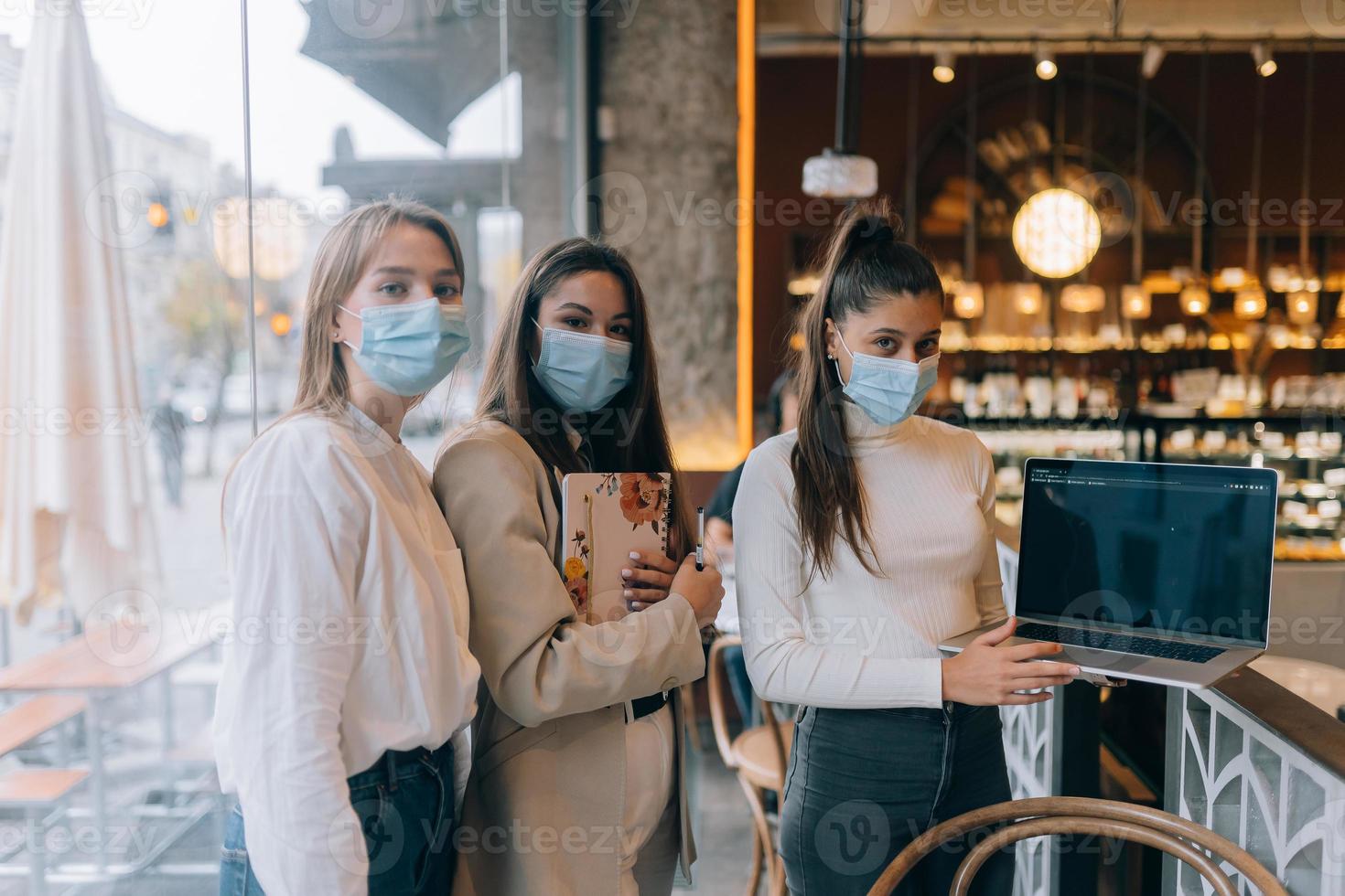 trois femmes d'affaires avec leurs masques faciaux débattant de différents points de vue sur le travail photo
