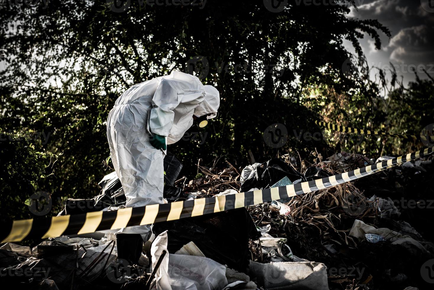 un scientifique asiatique porte une combinaison de protection chimique vérifie le danger chimique, travaille dans une zone dangereuse, prélève des échantillons en cas d'enquête sur le virus corona déclenchée par la chine. photo