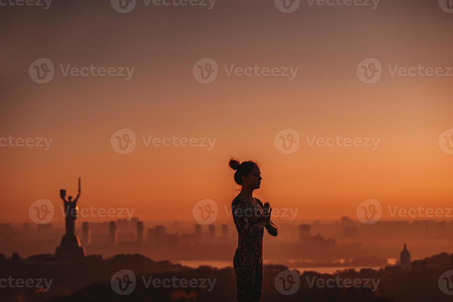 femme faisant du yoga sur le toit d'un gratte-ciel dans une grande ville. photo