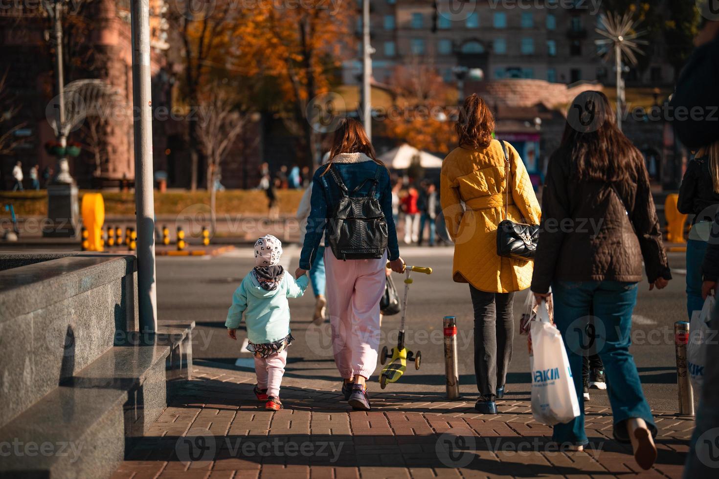 beaucoup de gens traversent la rue aux feux de circulation. photo