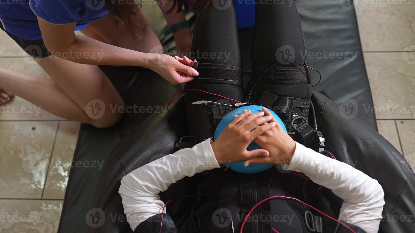 formation EMS. la fille se trouve dans un costume avec des câbles. photo