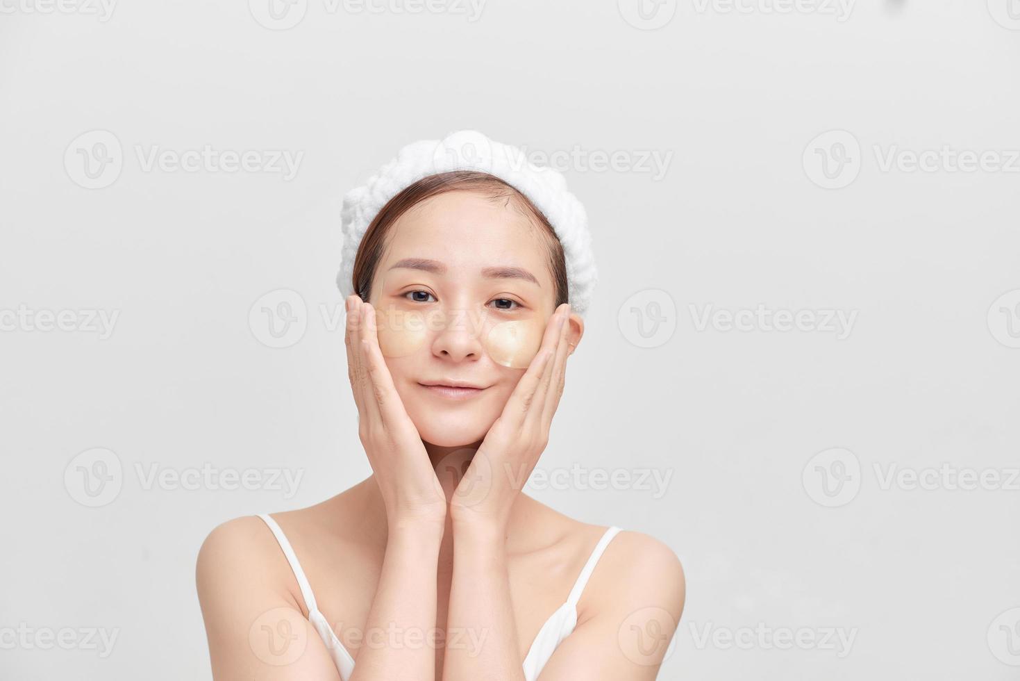portrait de beauté d'une jeune femme asiatique séduisante isolée sur fond blanc, portant une serviette sur la tête photo