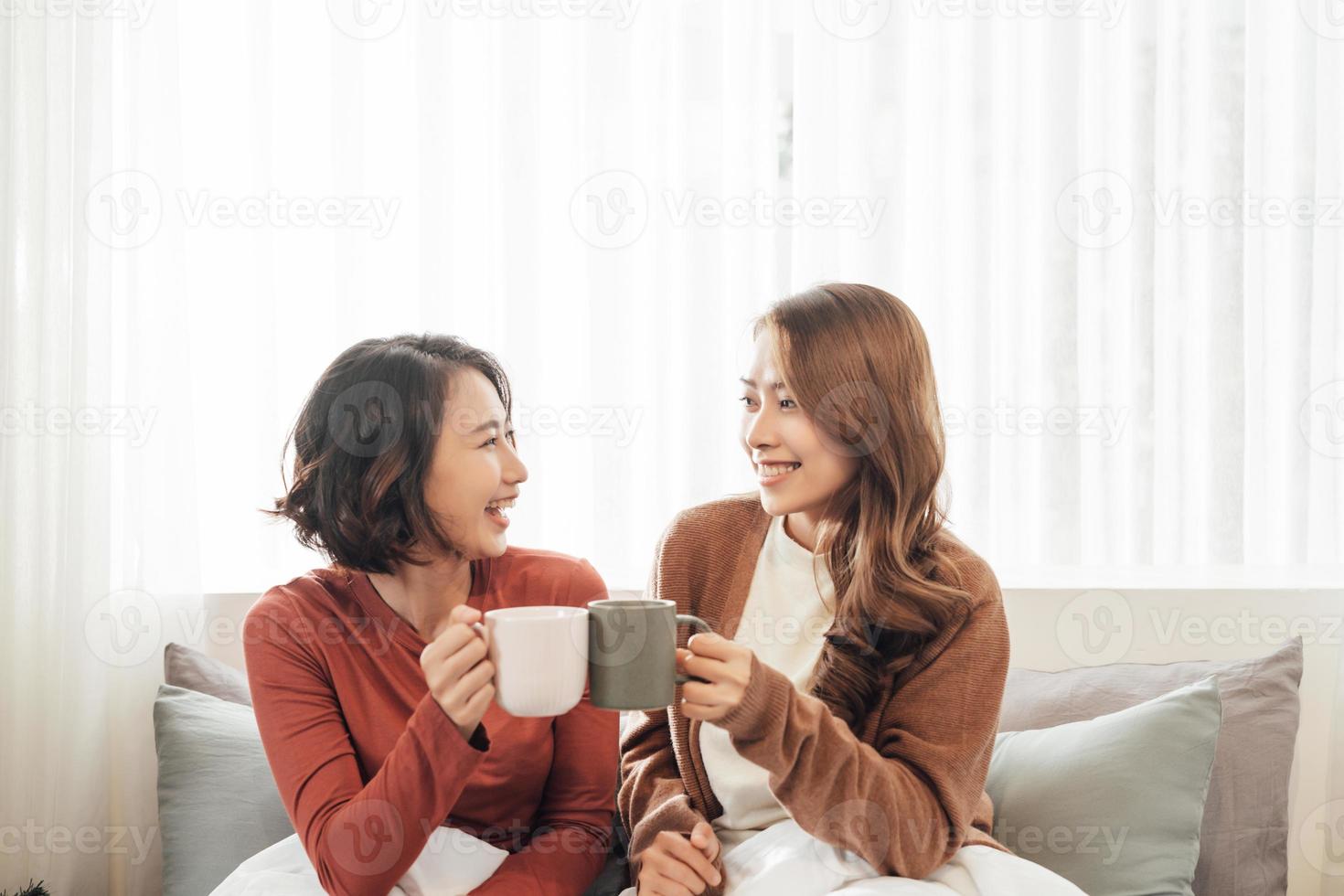 copines amis boivent du thé sur le canapé photo