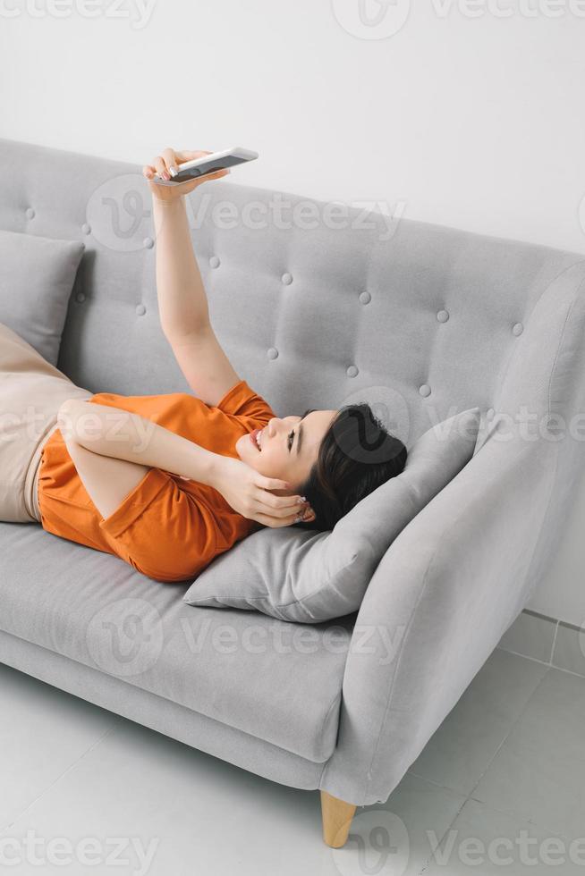 une femme de bonne humeur prend un selfie dans le salon. photo