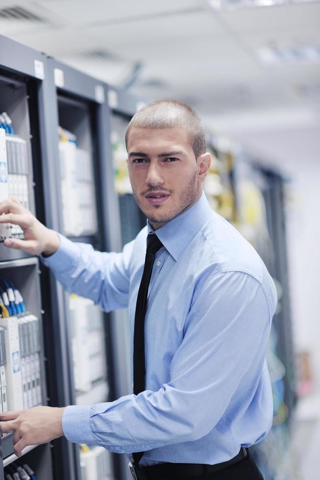 jeune ingénieur informatique dans la salle des serveurs du centre de données photo