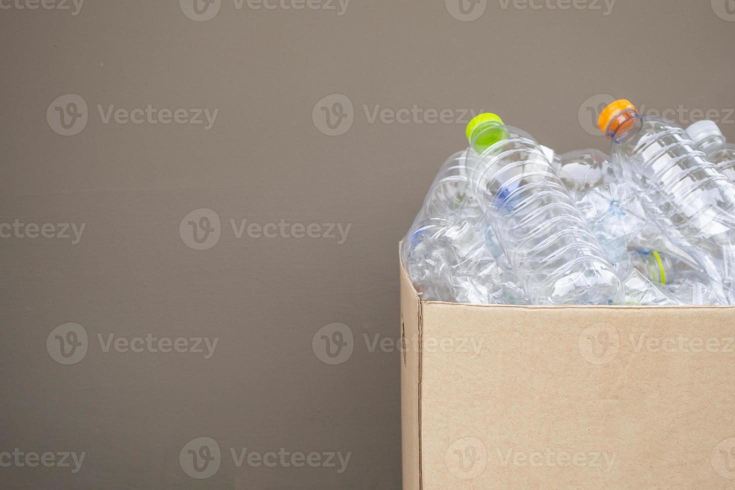 bouteilles en plastique dans une boîte à ordures recyclée brune photo