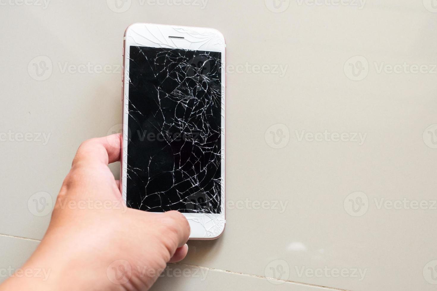 main tenant un téléphone portable avec écran en verre cassé photo