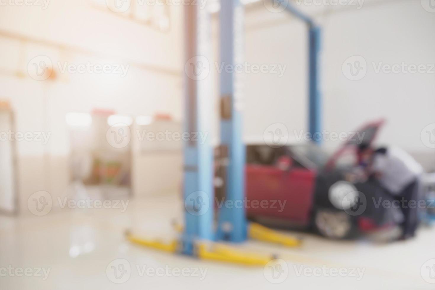 mécanicien travaillant dans un centre de service de réparation automobile arrière-plan flou photo