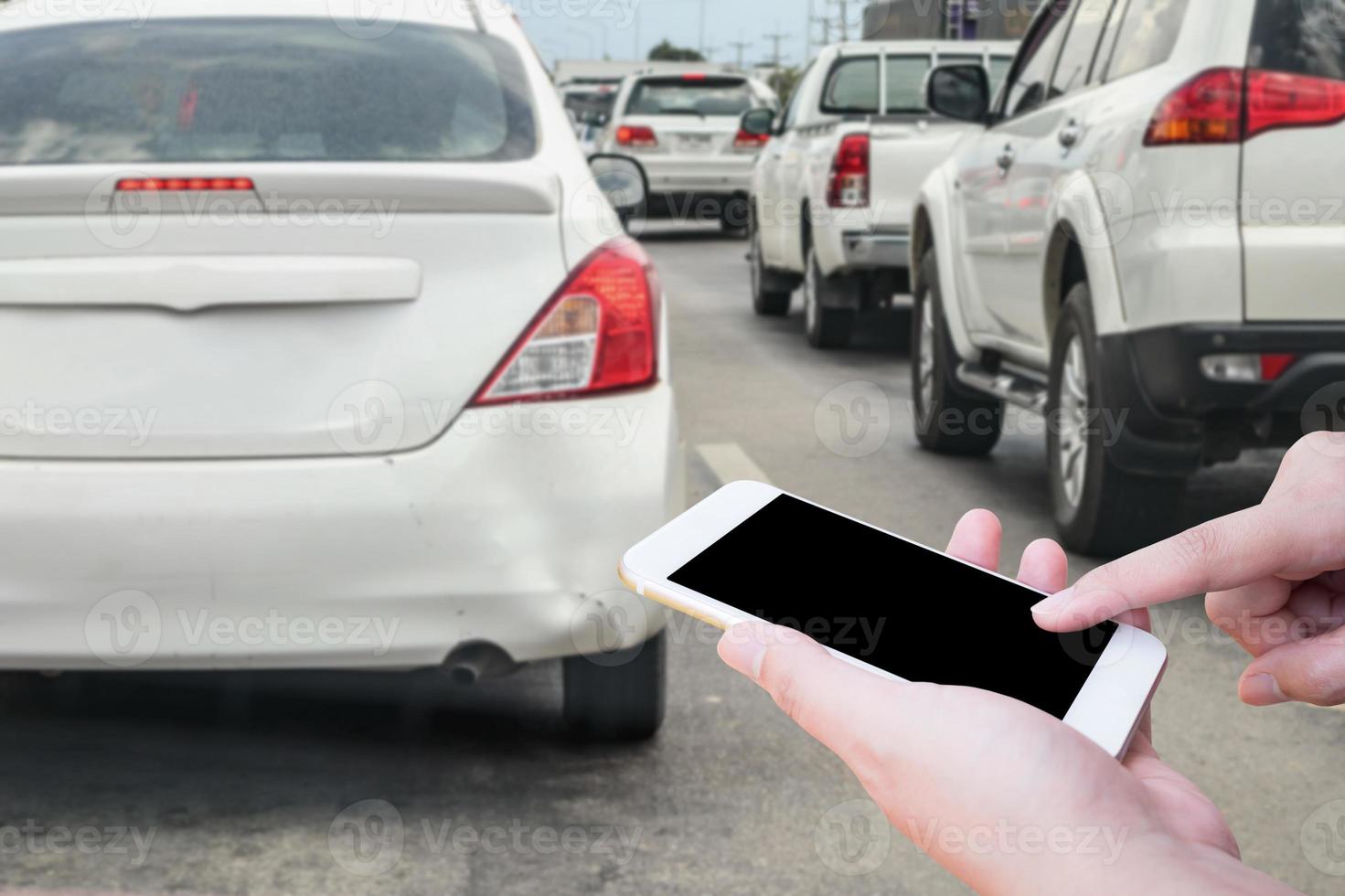 main de femme à l'aide d'un téléphone intelligent mobile après un accident de voiture dommage au pare-chocs pour l'assurance photo