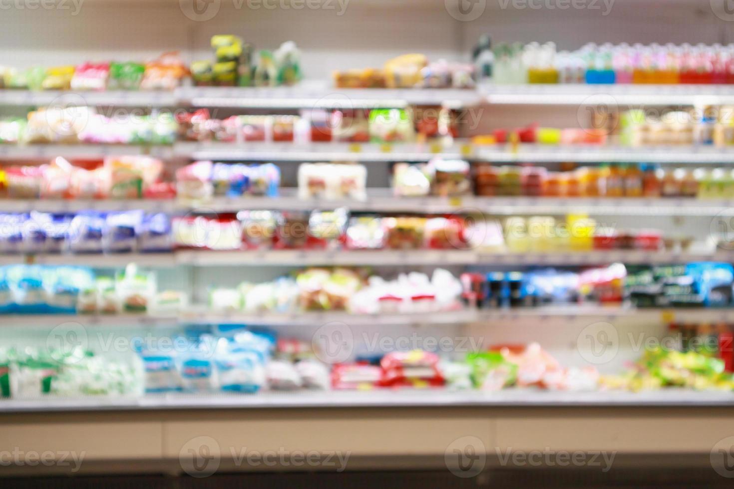 Étagères de réfrigérateur de supermarché avec produit de boisson gazeuse de jus de fruits abstrait arrière-plan flou photo