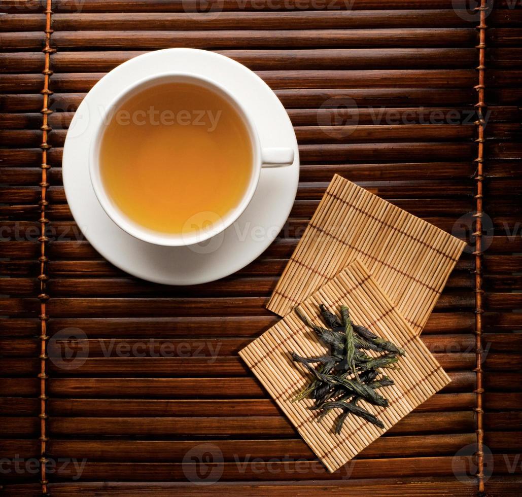 tasse de thé vert infusé avec des sous-verres en bambou photo