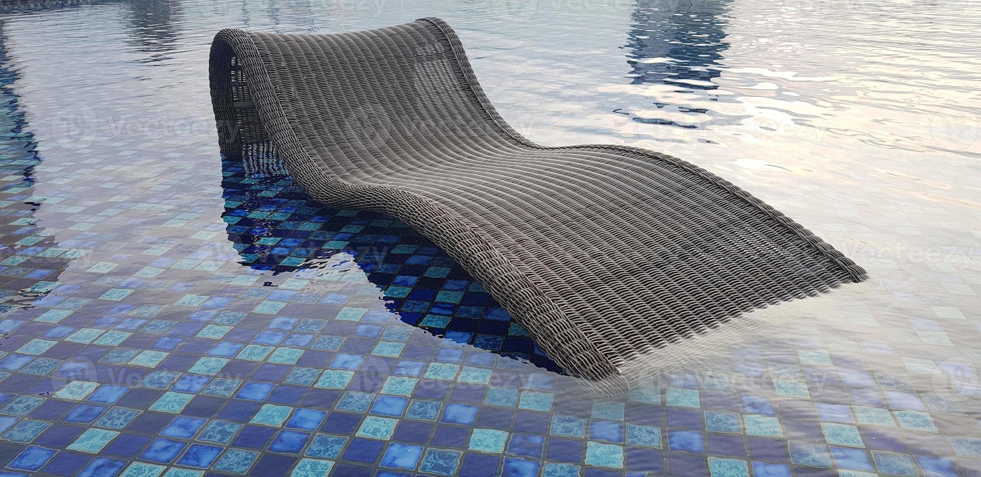 Détendez-vous sur une chaise longue au bord de la piscine bleue de la piscine d'un complexe thermal de luxe ou de l'industrie du tourisme de villas photo