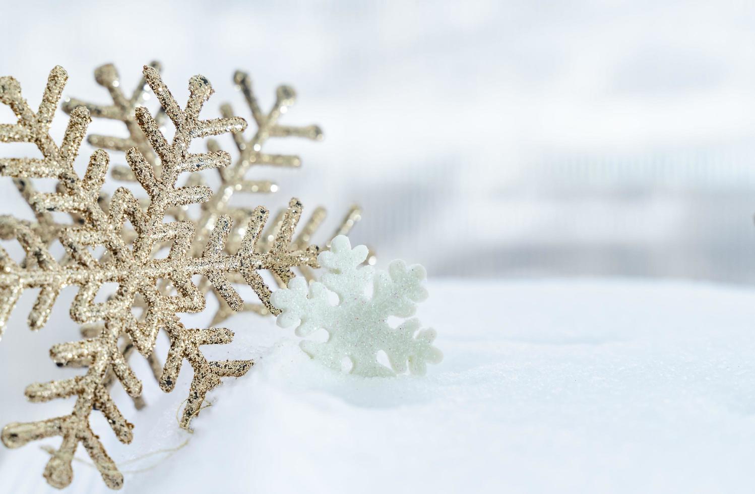 noël d'hiver - flocons de neige de noël sur la neige, concept de vacances d'hiver. décorations de flocons de neige blancs et dorés sur fond de neige photo