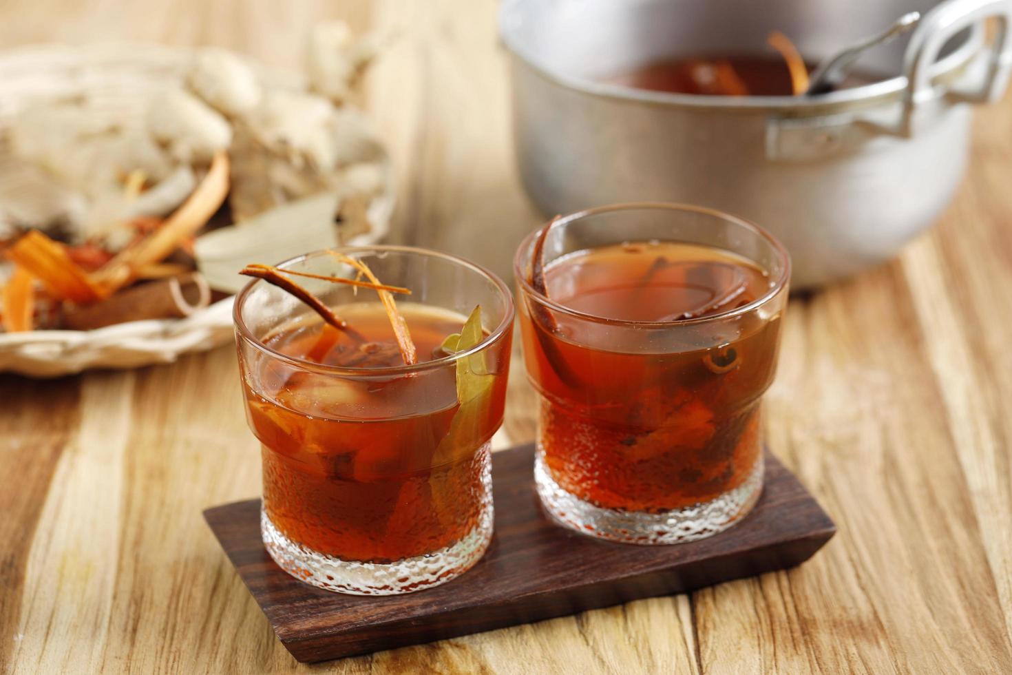 wedang uwuh, boisson chaude traditionnelle de yogyakarta. fait avec diverses épices. servi dans un verre avec du sucre candi. photo