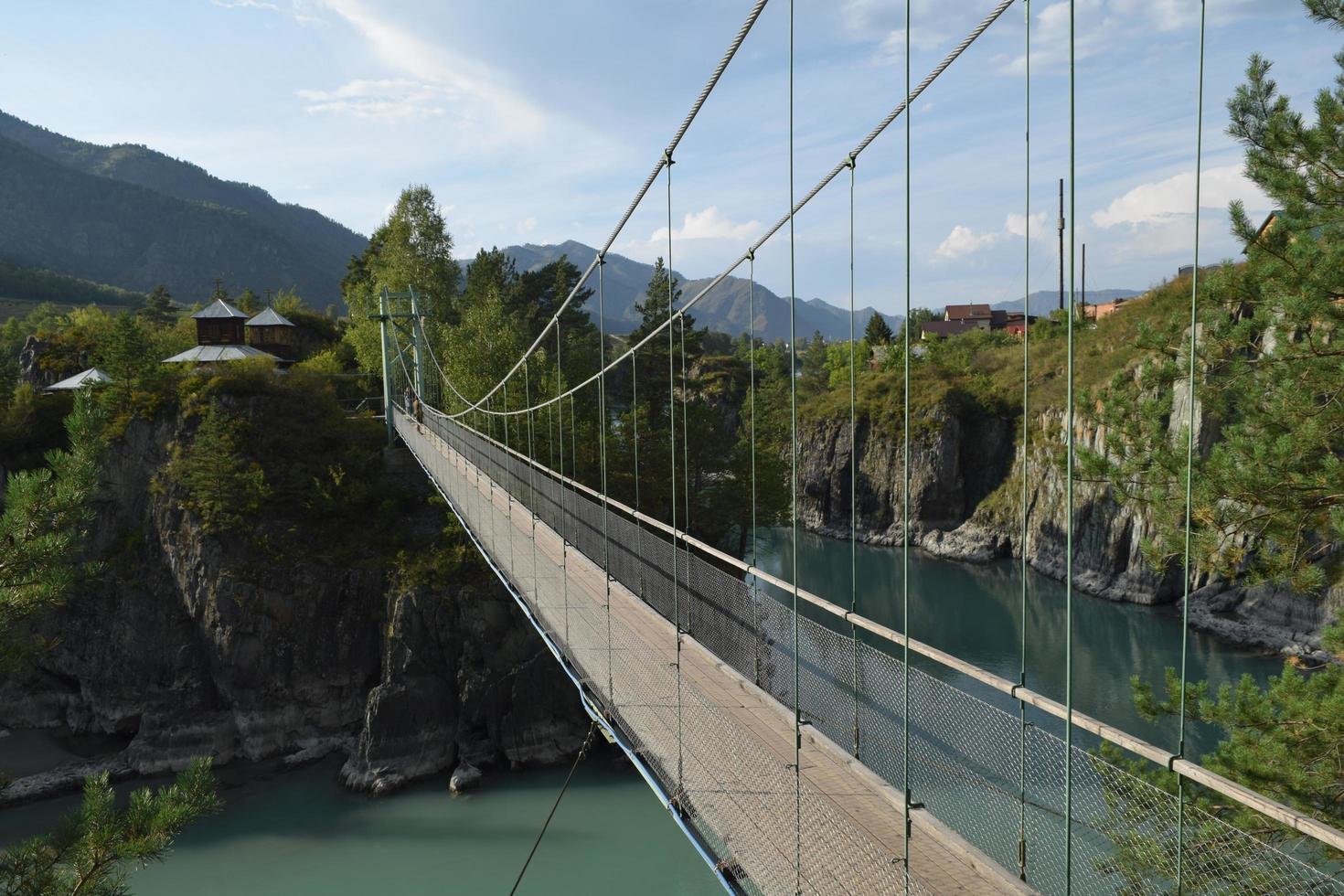 pont suspendu au-dessus de la rivière de montagne photo